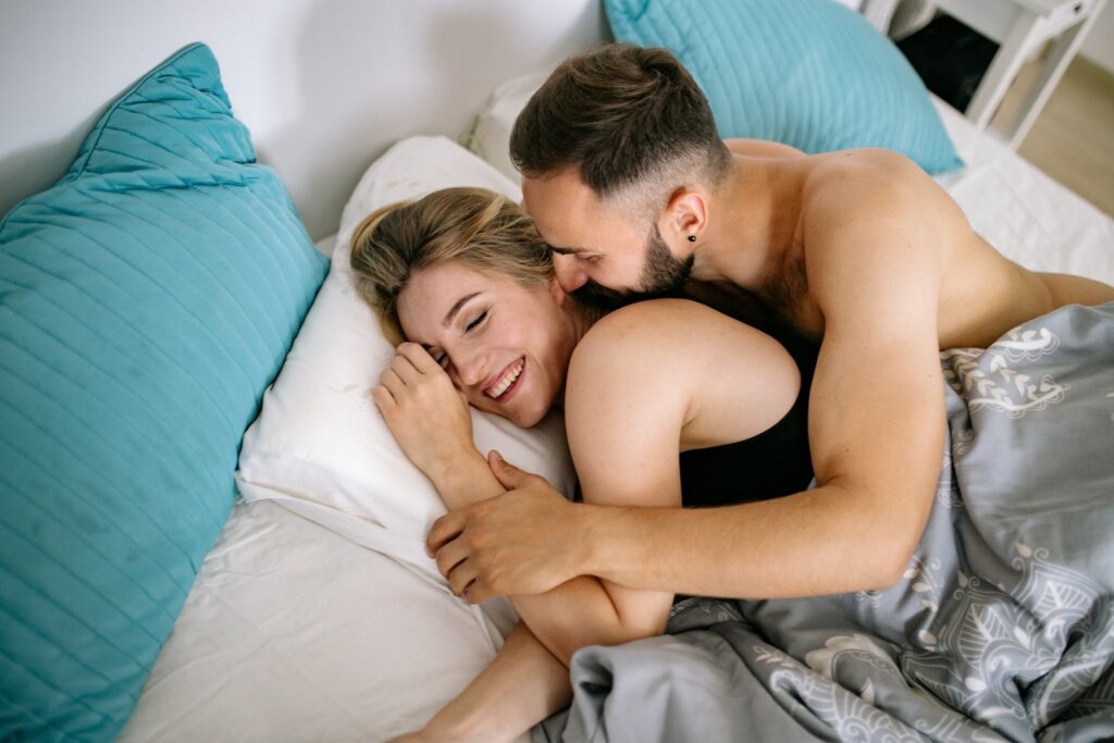 Man Embracing Woman Lying in Bed