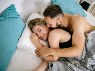 Man Embracing Woman Lying in Bed