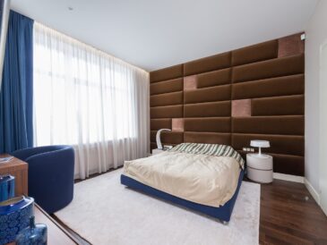 Interior of contemporary bedroom with comfortable soft bed and stylish furniture in flat in daytime