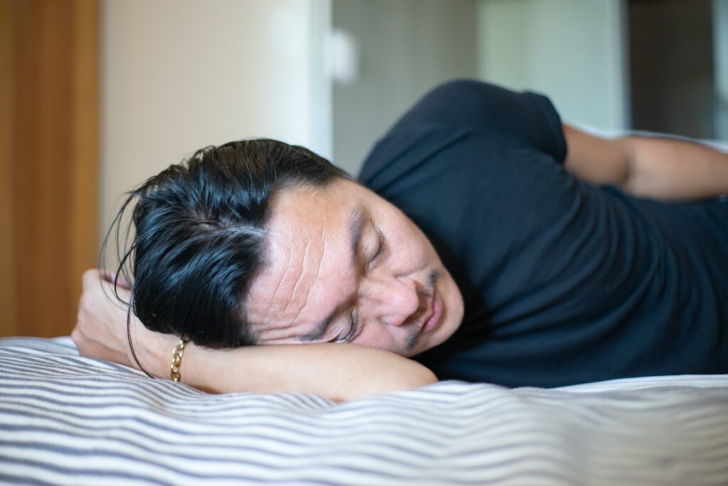 A Person Wearing Black Shirt Sleeping on Bed