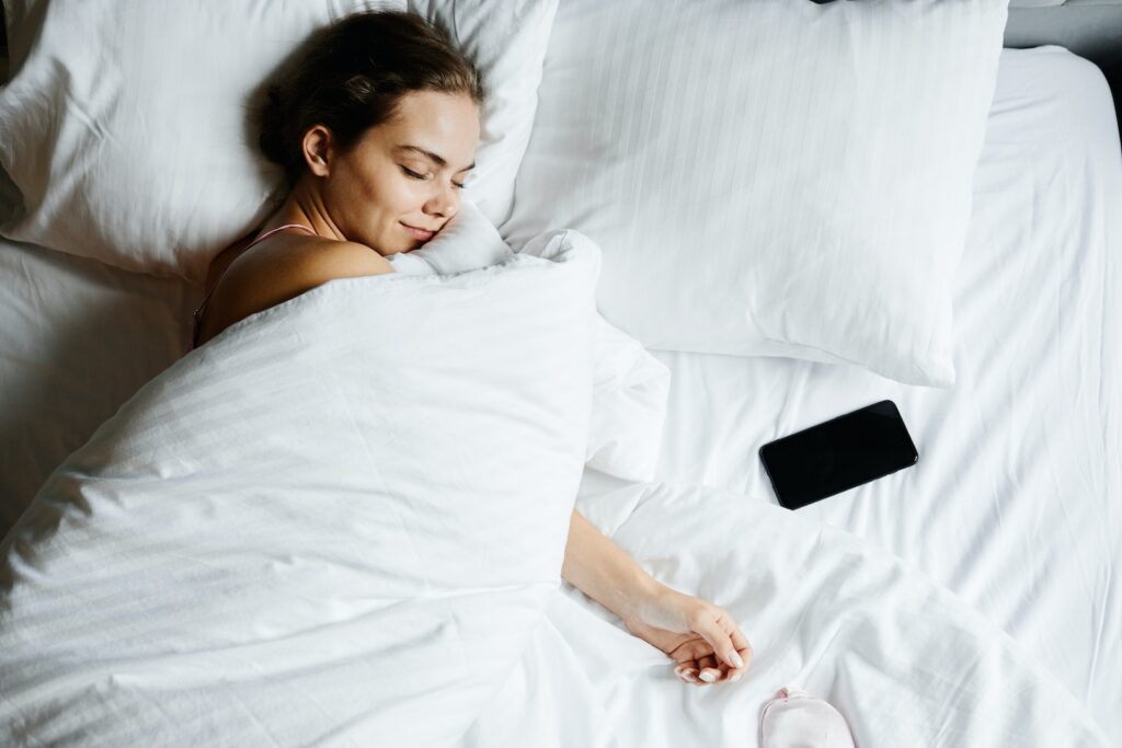 A Woman Sleeping Beside Her Smartphone