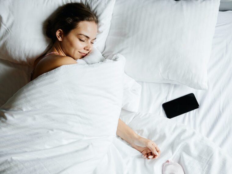 A Woman Sleeping Beside Her Smartphone