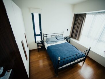 blue and white bed sheet and black bed frame in room