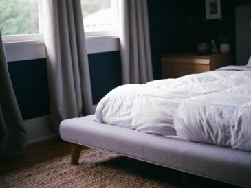 white bed by the window during daytime