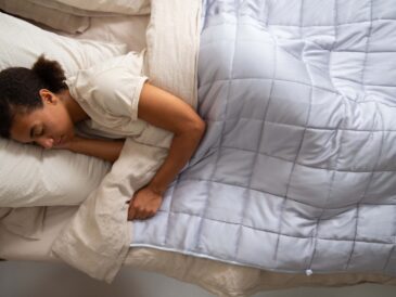 a woman sleeping in a bed with a white comforter